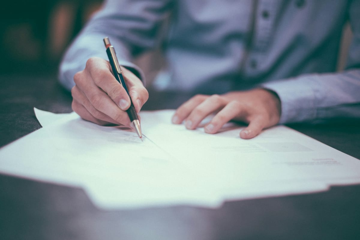 Paper documents and a pen on a desk during a quiet writing session